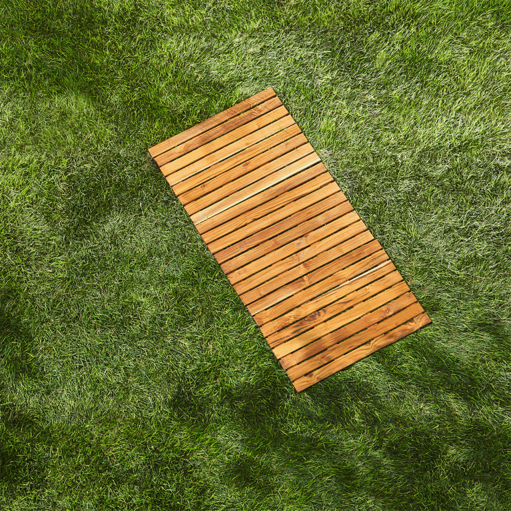 Wooden slat mat on grass, overhead view