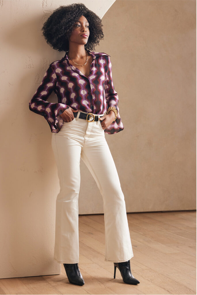 Woman in a patterned blouse and white pants