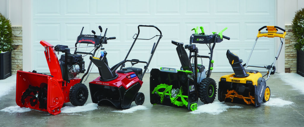 Row of snow blowers lined up in a garage