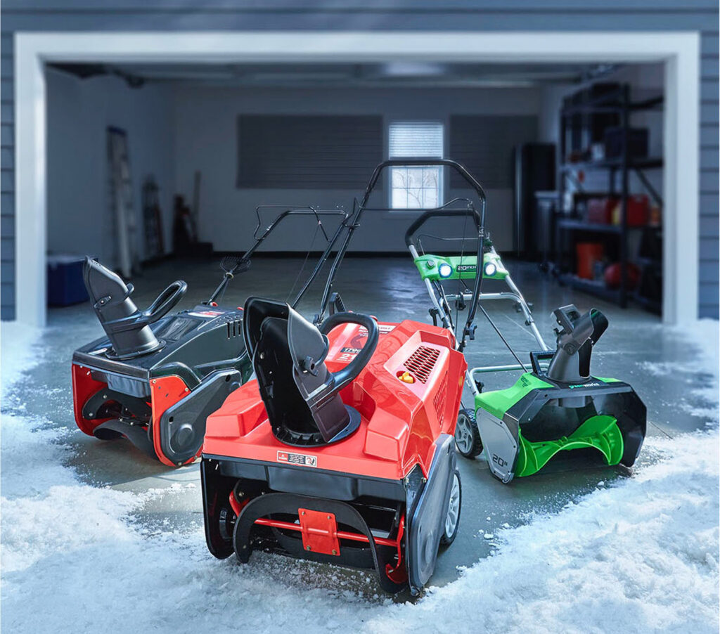 Snow blowers parked in a garage in the snow