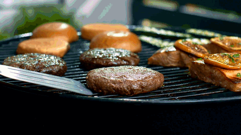 Burgers and buns grilling on a barbecue