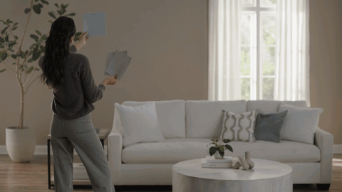 Woman decorating a living room wall
