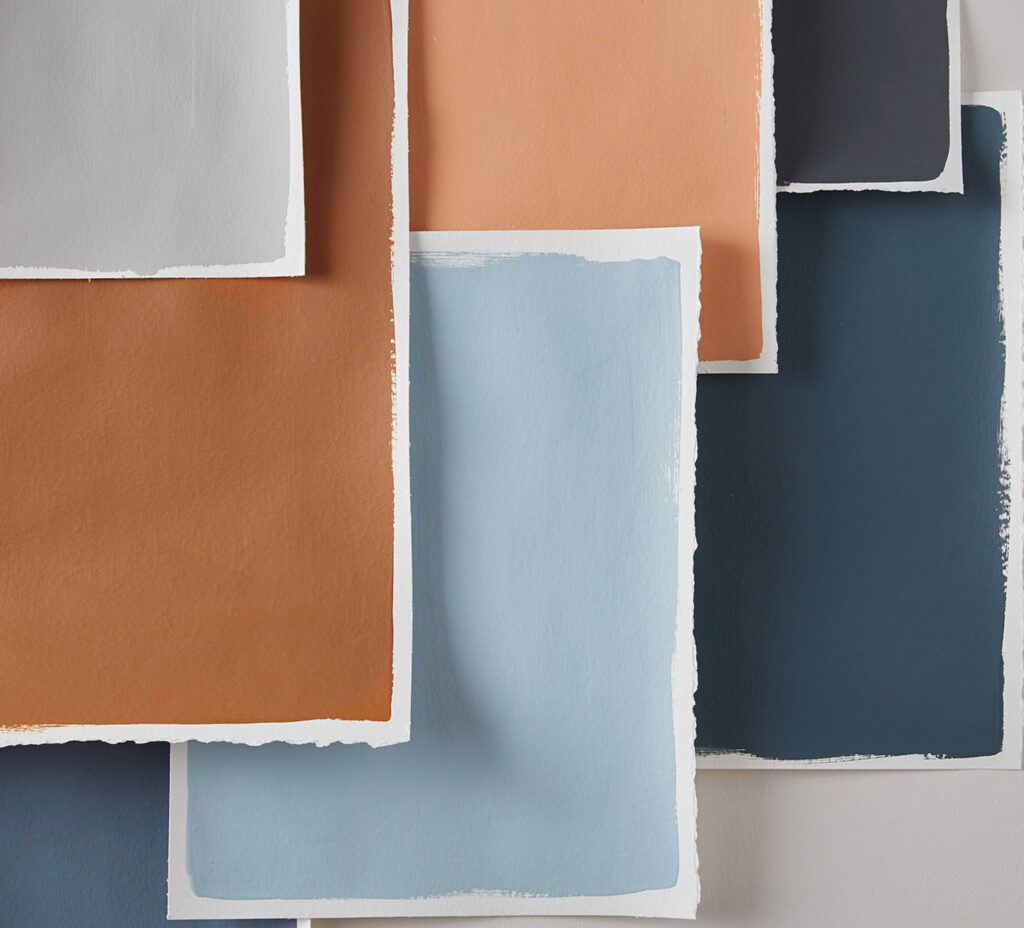 Paint color swatches in orange and blue tones on a wall