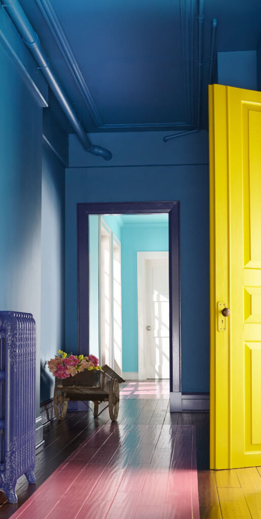 Hallway with blue walls and a bright yellow door