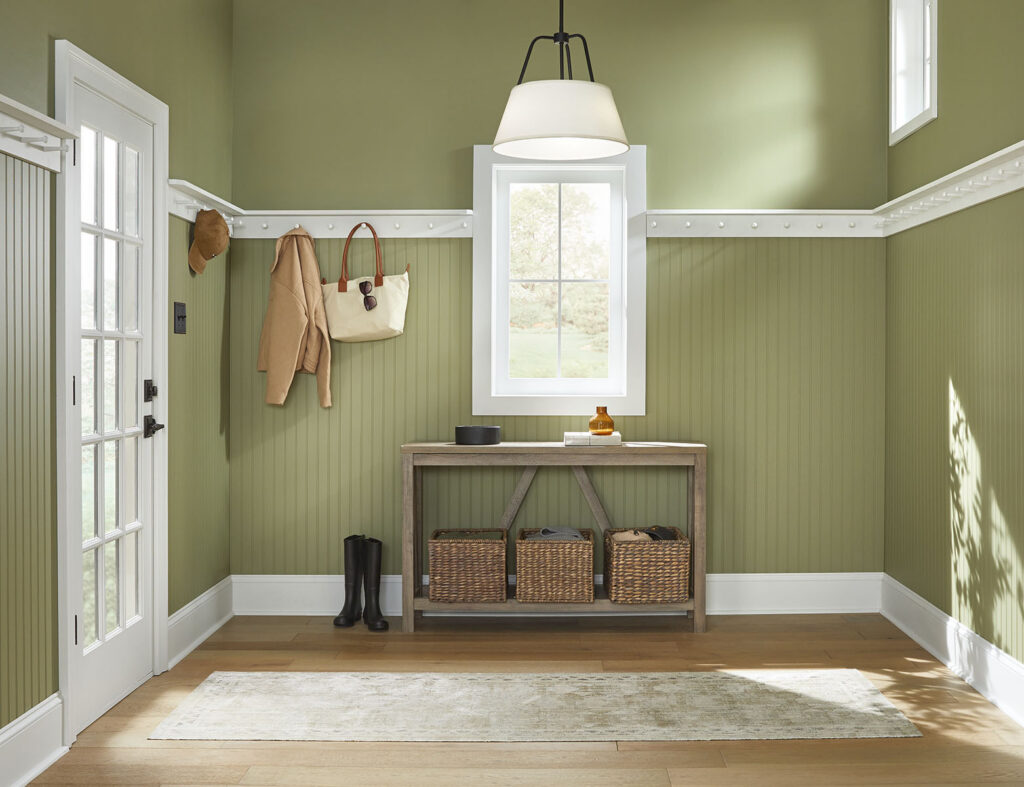 Entryway with green painted walls and a bench