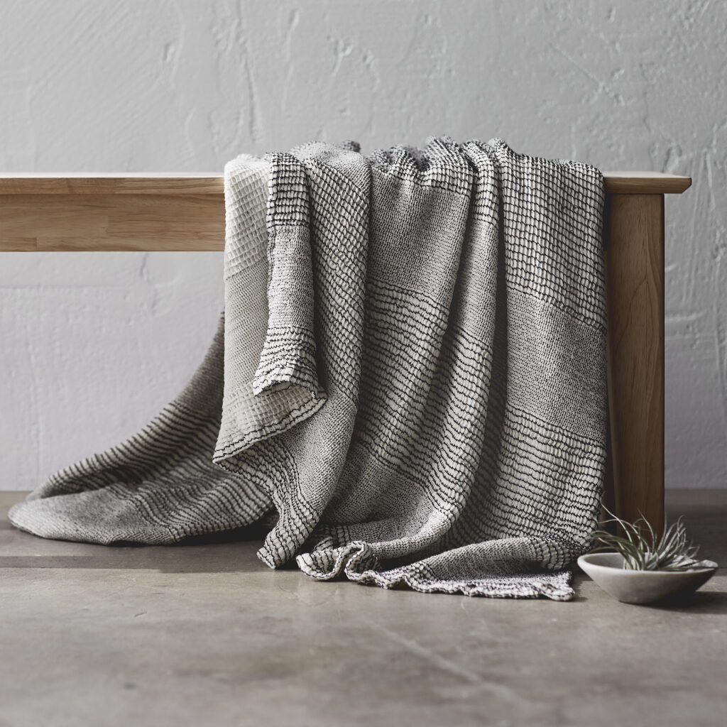 Gray throw blanket draped over a bench