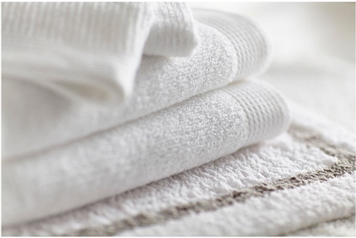 Folded white towels on a bath mat
