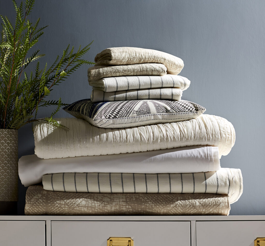Stack of folded towels and blankets on a dresser