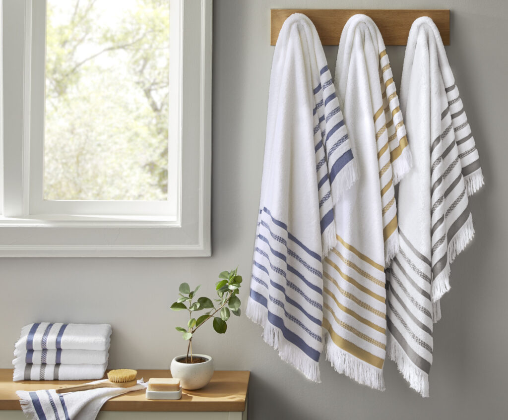 Striped towels hanging on a bathroom wall by a window