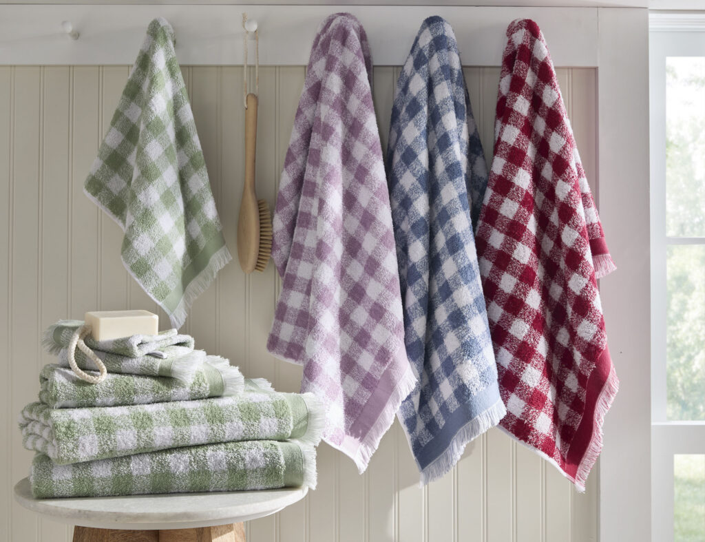 Plaid towels hanging on hooks with folded towels