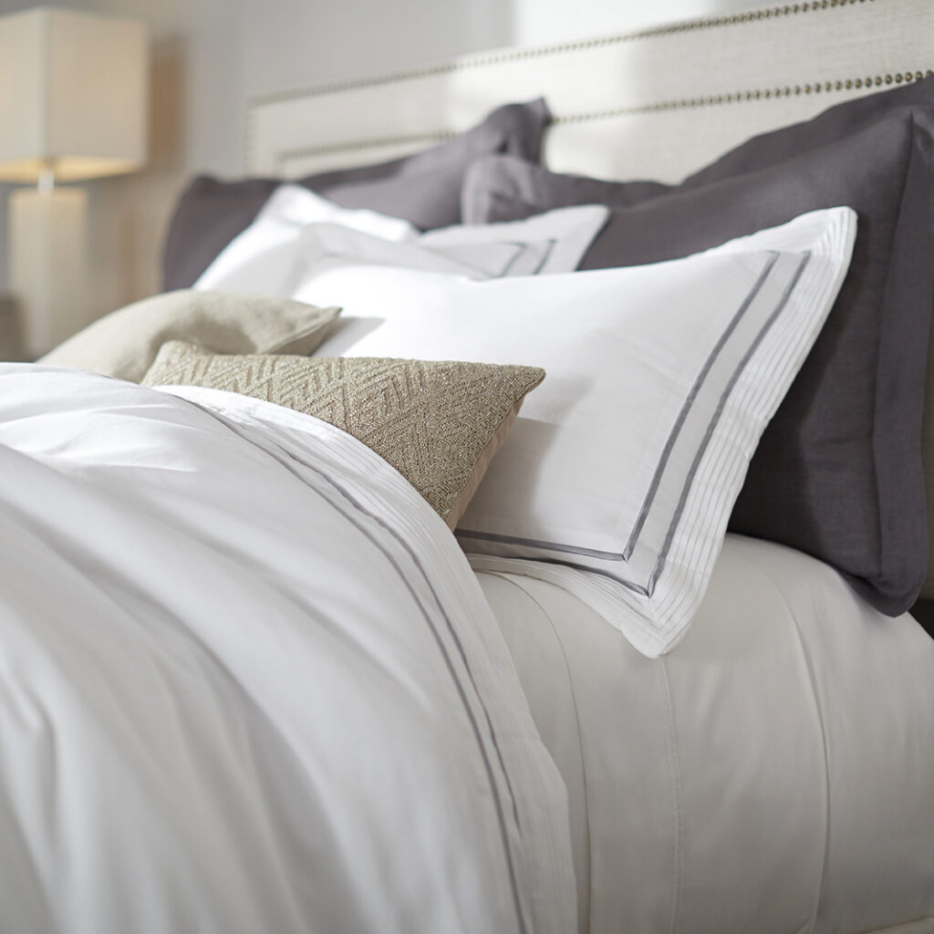 Bed with white and gray bedding and pillows