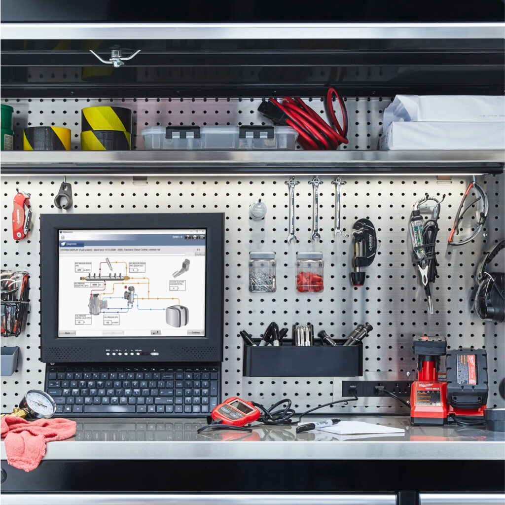 Workshop pegboard wall with tools and a tablet