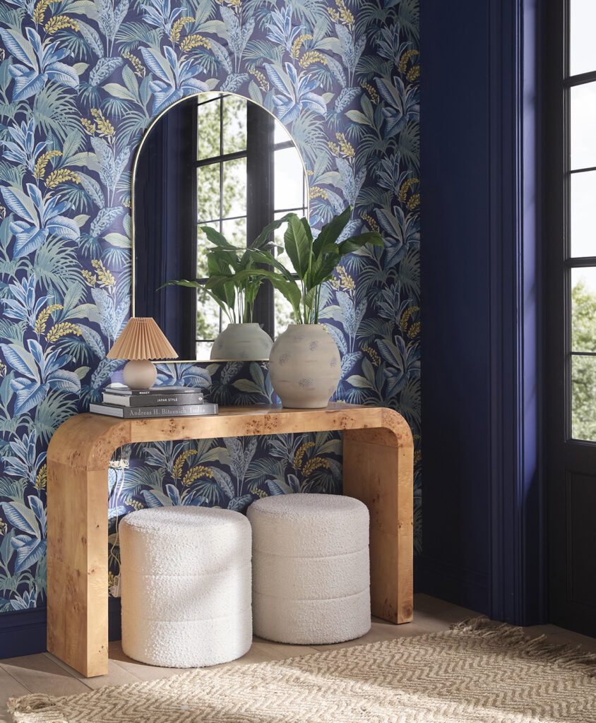 Entryway with blue tropical wallpaper, console and round mirror