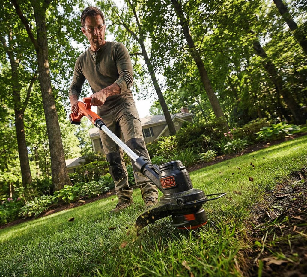 man with black & decker lawn tool trimmer